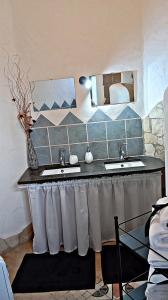 a bathroom with two sinks and two mirrors at Nicola appartamento in Giba +8 photos