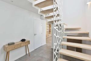 - un escalier dans une chambre dotée de murs blancs et de parquet dans l'établissement Luxury villa with pool, à Les Sables-dʼOlonne