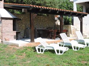 a group of white chairs sitting in the grass at Apartment Areta in Ravni