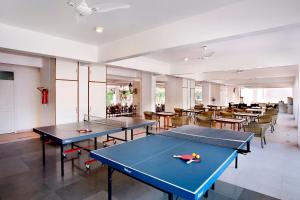 una habitación con mesas de ping pong y sillas en Villa San Lawrenz en Lonavala