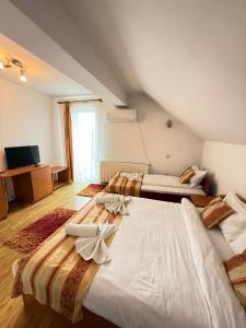 a bedroom with two beds with bows on them at Pensiunea Tudor in Baile Felix +15 photos