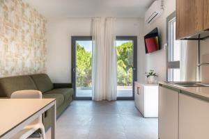 a kitchen and living room with a couch and windows at One Life Suites in Bibione