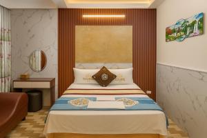 a hotel room with a bed and a chair at Nhà Nghỉ Thu Hằng 1 in Hà Ðông