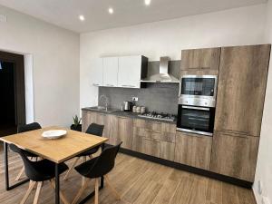 a kitchen with a wooden table and a dining room at Stagnone Sunset Holidays in Marsala