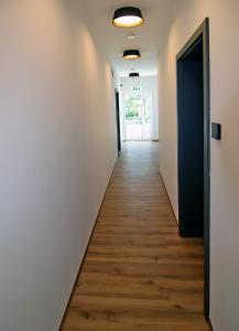 an empty hallway with white walls and wooden floors at Hotel Falken in Hechingen
