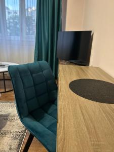 a room with a table and a chair and a television at Henriett’s cosy place in Satu Mare