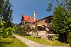 a house with a red roof and a pathway at Pensiunea Bucuria Cheia & Ferma Animale in Cheia