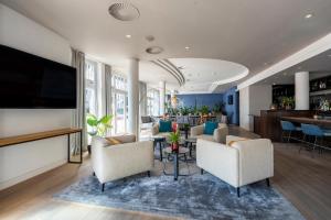 a living room with chairs and a flat screen tv at Hotel NEWBERLIN in Berlin