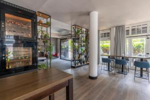 a living room with a fireplace and a table and chairs at Hotel NEWBERLIN in Berlin