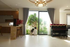 une femme agenouillée devant une porte vitrée dans l'établissement Peace Villa, à Dong Quan