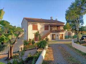 a large white house with a driveway at Qui vive un sogno in Roccastrada