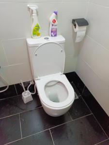 a bathroom with a toilet with cleaning products on it at SPACIOUS 2 AND 3 BEDROOM APARTMENTs in Mtwapa +23 photos