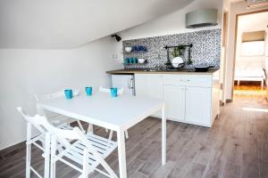 a kitchen with a white table and two white chairs at Apartments Rajna in Zaboric