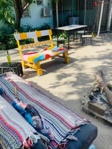 a colorful bench sitting next to a table with a blanket at Home Choice in Maun