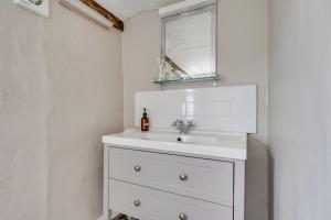 ein Badezimmer mit einem weißen Waschbecken und einem Spiegel in der Unterkunft Winter Cottage, Clare in Clare + 19 Fotos