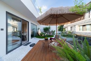 a patio with a wooden deck with an umbrella at Warm Shore in Taiping