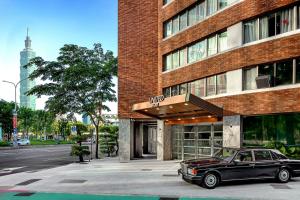 a car parked in front of a brick building at United Hotel in Taipei