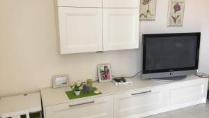 a tv sitting on top of a white dresser at BnB Cairoli - Homezon in Diano Marina