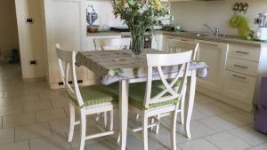 a kitchen with a table with chairs and a vase of flowers at BnB Cairoli - Homezon in Diano Marina