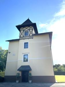 a white building with a clock tower on top at APARTMENT KLAGENFURT Villa Frank No1 - with Free Parking, Air Conditioning, Smart-TV & Self Check-in in Klagenfurt