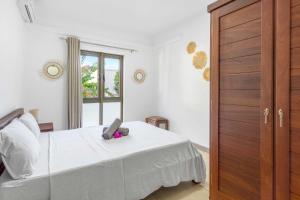 Un dormitorio con una cama blanca y una ventana. en Casa Martello by IHR, en Rivière Noire 24 fotos más