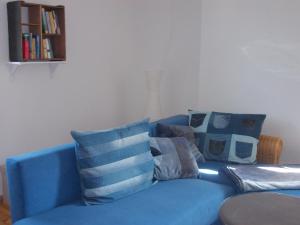 a blue couch with pillows on it in a living room at Ferienwohnung Neubert in Eibenstock +18 photos
