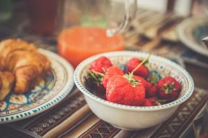 a bowl of strawberries next to a plate of food at Nomad B&B in Gaeta