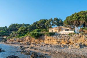 a house on a cliff next to the water at Casa del mare in Pyrgos