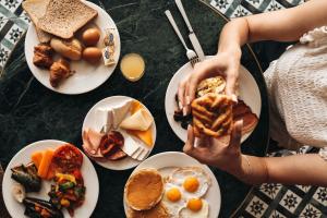 a table with plates of breakfast food on it at Leonardo Boutique Hotel Larnaca in Larnaca