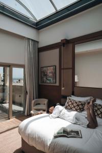 a woman laying on a bed in a bedroom at Leonardo Boutique Hotel Larnaca in Larnaca