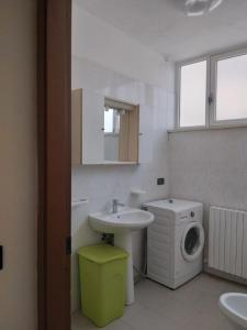 a bathroom with a sink and a washing machine at Casa Martini in Lido degli Estensi