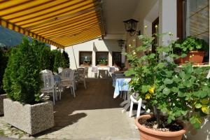 een patio met een tafel, stoelen en planten bij Pension Rita in Silandro