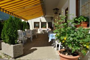 a patio with a table and chairs and plants at Pension Rita in Silandro