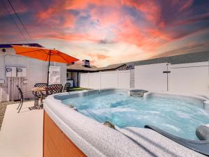 a hot tub on a patio with an umbrella at Drew 251 Mesa in Mesa