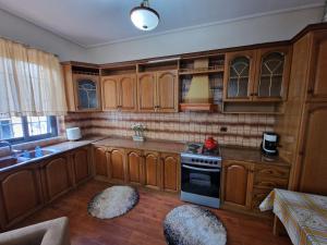 a kitchen with wooden cabinets and a stove at The Koplik Guesthouse in Koplik