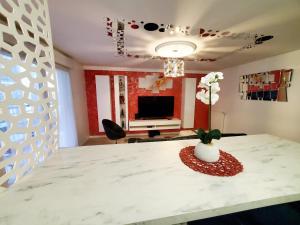 une pièce avec une table avec un vase de fleurs dessus dans l'établissement Le Petit Versailles, à Franconville 14 autres photos