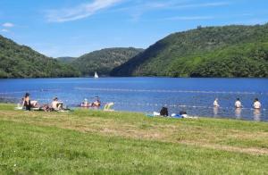 a group of people sitting in the water at a lake at Mobil-home chalet chez l'habitant, au coeur des Combrailles, à 5 min du Pont du Bouchet in Saint-Priest-des-Champs