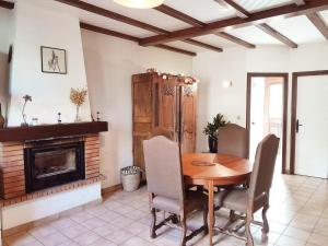 a dining room with a table and a fireplace at Maison de Campagne in Treffléan