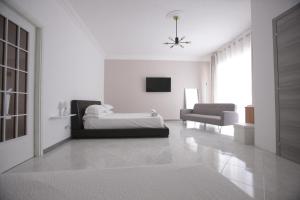 a white living room with a bed and a couch at Dream on the Blue House in Valderice