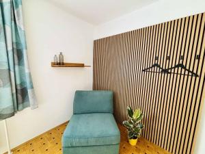 a blue chair and a plant in a room at Ferienwohnung Janisch in Mank