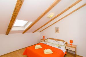 1 dormitorio con 1 cama con manta naranja en Apartments Pavle, en Dubrovnik
