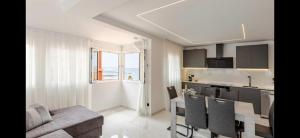 a kitchen and living room with a table and a couch at Azure Bliss in Costa de Adeje