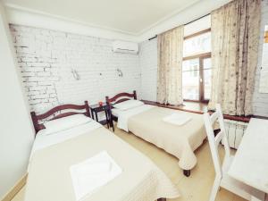 two beds in a room with a brick wall at Mini Hotel Chistoprudniy in Moscow