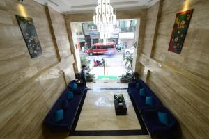 um corredor com cadeiras azuis e um lustre num edifício em Hanoi Emerald Waters Hotel & Spa em Hanói