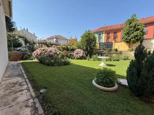 a yard with a green lawn with bushes and flowers at Miresileón in León