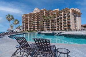 a resort with chairs and a swimming pool with a hotel at Wait 'n Sea Retreat Spacious Oceanfront Condo in Puerto Peñasco