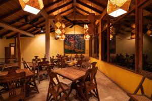 a restaurant with wooden tables and chairs in a room at Cinnamon Museum Mirissa in Mirissa +14 photos