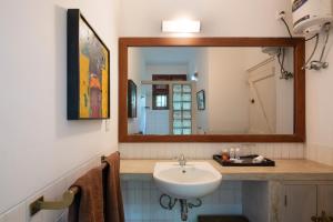 a bathroom with a sink and a mirror at Cinnamon Museum Mirissa in Mirissa