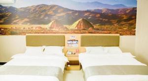 two beds in a room with a painting on the wall at Thank Inn Hotel Ningxia Yinchuan Xixia District Tongxin Road in Yinchuan