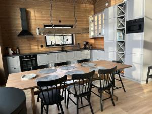 a kitchen with a wooden table and black chairs at Borgahyllan 2 in Borgafjäll
